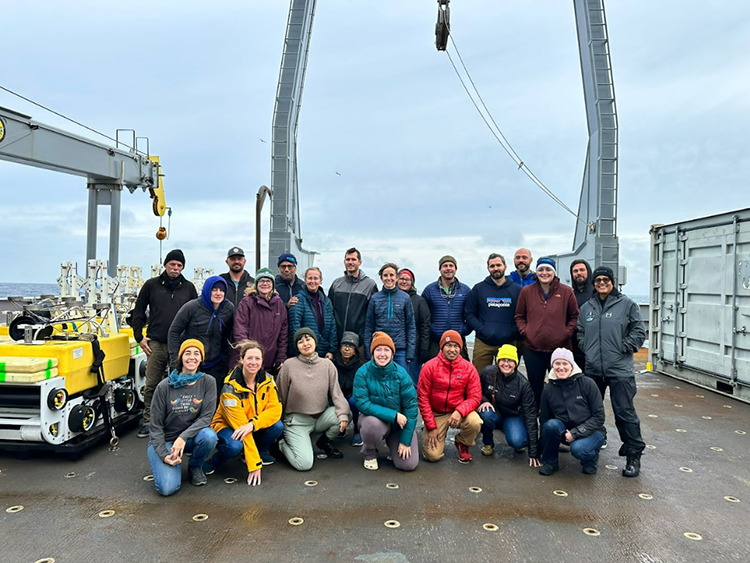 Photo of a group of people on the back of a research vessel.