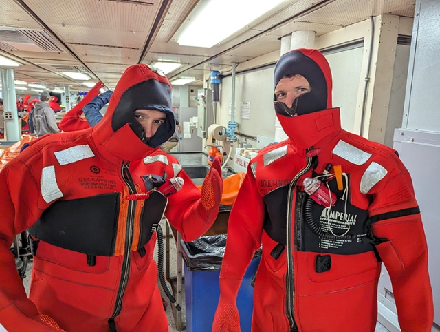 Two STEMSEAS participants try on bulky Neoprene immersion suits.