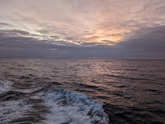 A photograph of the ocean at sunrise